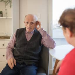 Man cups ear in effort to hear