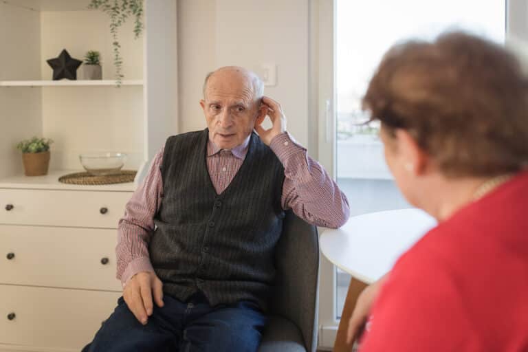 Man cups ear in effort to hear Man cups ear in effort to hear