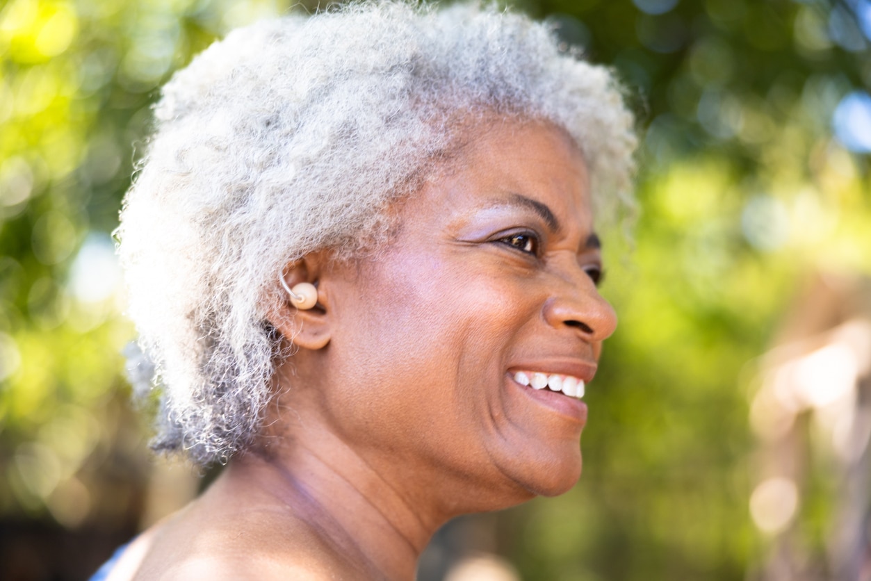 Woman with hearing aid smiles Woman with hearing aid smiles